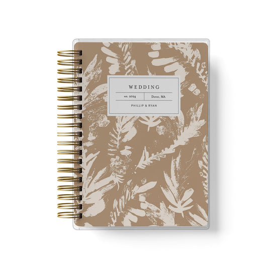 Shown in a neutral boho leaf design, our exclusive LGBT wedding planner books are all-inclusive and gender-neutral