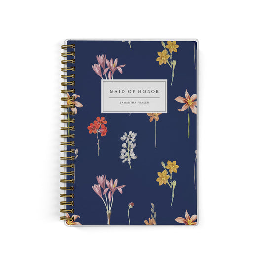 Our exclusive maid of honor planners are the perfect gift for your best friend, shown in a dark floral botanical print