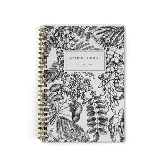 Our exclusive maid of honor planners are the perfect gift for your best friend, shown in a black and white ferns & foliage print